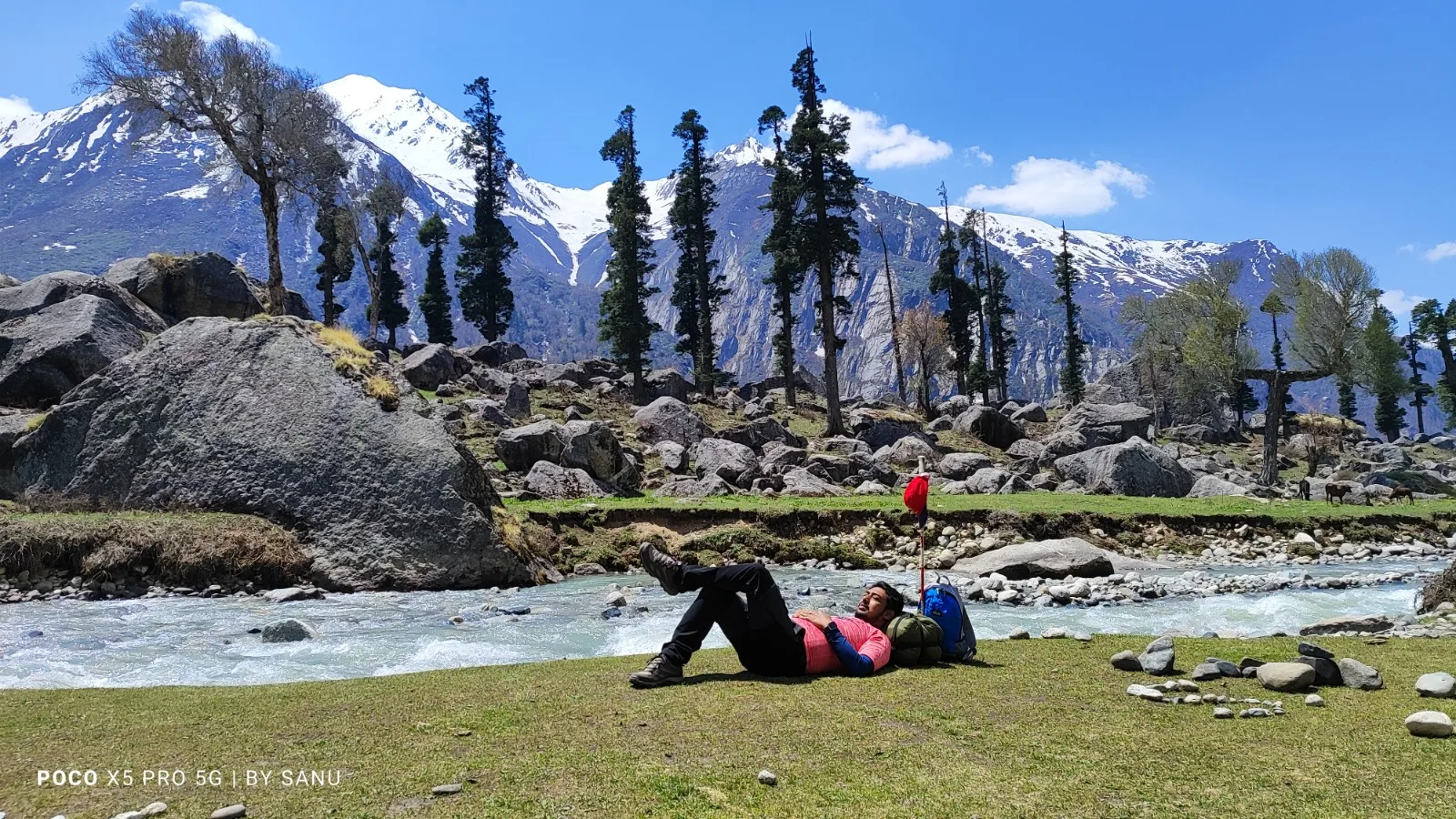Resting by the river with snow peaks behind